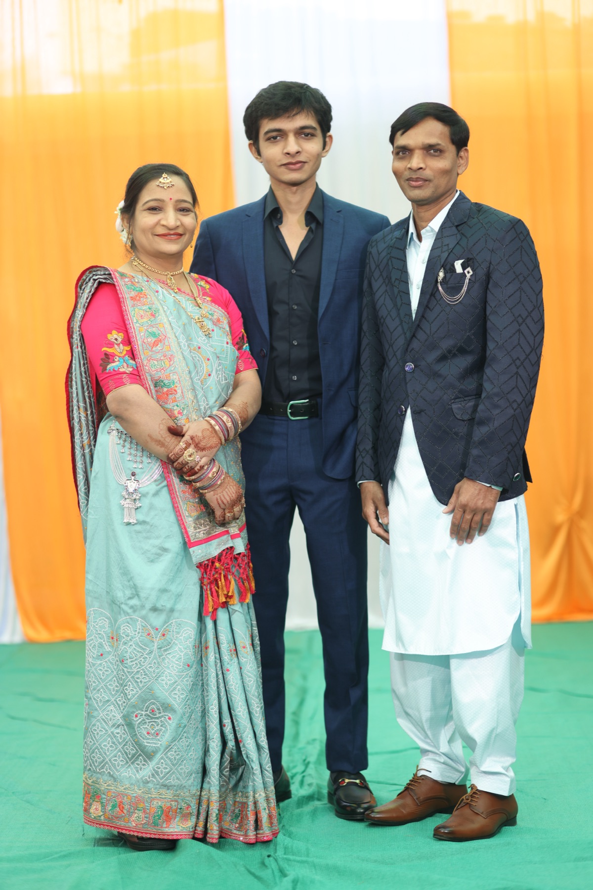 Dhruv standing between his mother and father